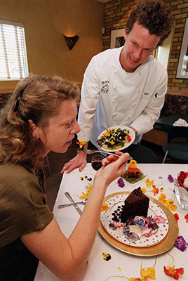 Man serving woman cake decorated with flowers