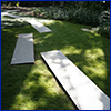 Long rectangles of diamond patterned sheet metal laid as a walkway on a lawn