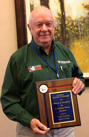 Luke Connor with his plaque for Outstanding Master Gardener of 2015