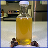 A glass bottle of honey colored liquid soap made from soapberry