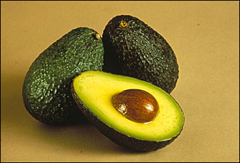 Avocados, one cut open so that seed is visible