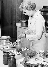Black and white photo of woman in kitchen