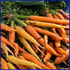 A pile of orange carrots at a farmers market