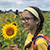 A smiling girl holding a sunflower in a field