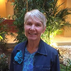 Ann Fender has short white hair, a gentle smile, and is wearing a denim jacket