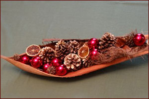 Pine cones and ornaments in dried palm boat