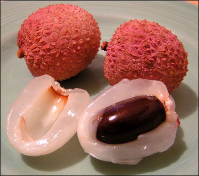Lychee cut open to reveal white flesh and dark seed
