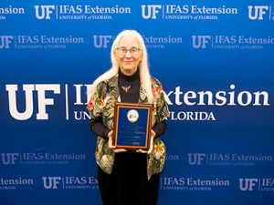 Smiling woman from Polk County holding a plaque.