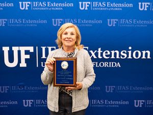 Smiling woman holding a plaque