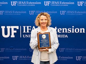 Smiling woman holding plaque