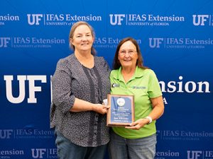 Two women holding a plaque and smiling