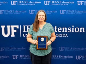 Smiling woman holding plaque