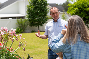 Leon County Extension agent Mark Tancig speaks with a homeowner in her yard.