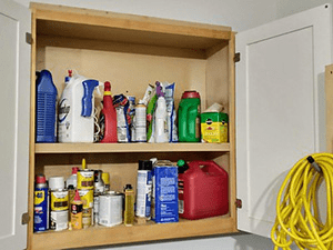 A garage cabinet full of bottles