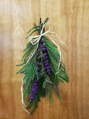 Final product hanging upside down by stems on a door