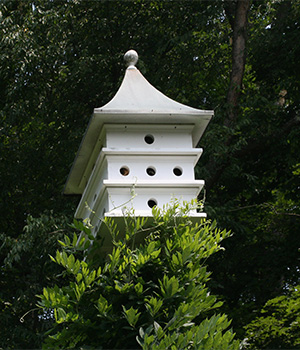 A white three-story birdhouse