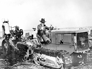 A black and white photo of Luther Burbank after whom the Burbank potato is named. He's driving a tractor.